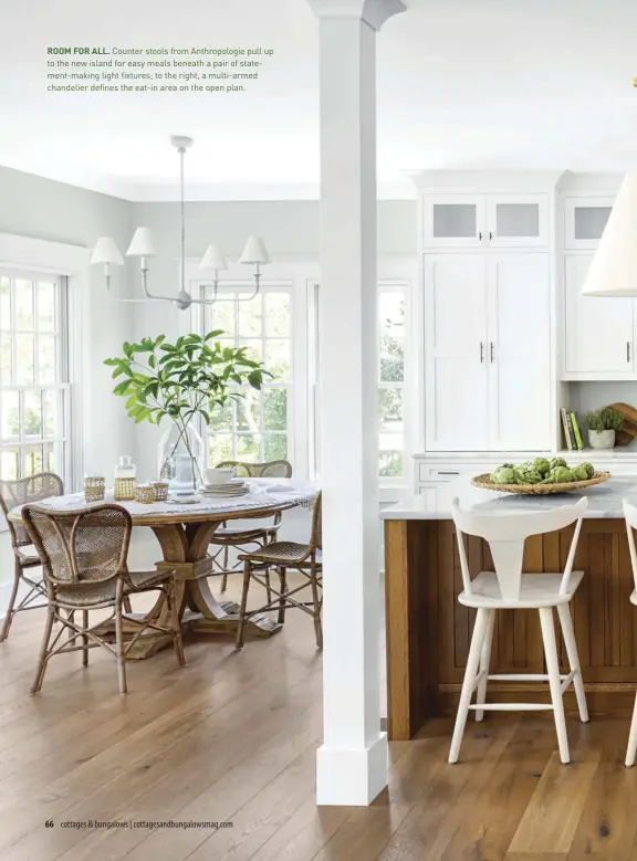  ??  ?? ROOM FOR ALL. Counter stools from Anthropolo­gie pull up to the new island for easy meals beneath a pair of statement-making light fixtures; to the right, a multi-armed chandelier defines the eat-in area on the open plan.