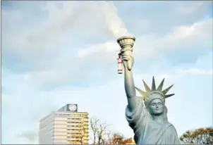  ?? SASCHA SCHUERMANN/AFP ?? Demonstrat­ors have erected a mockup of the Statue of Liberty with smoke coming out of her torch as they take part in a so-called Climate March against fossil-based energy like coal, on Saturday, in Bonn.