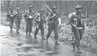  ??  ?? Canadian soldiers walk along a road near Arnhem, Netherland­s, in April 1945.