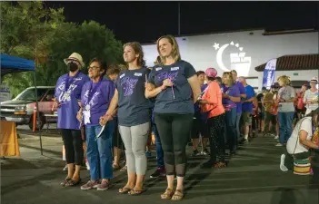  ?? Bobby Block/The Signal ?? Attendees at the Santa Clarita Relay for Life link arms as they hold glowsticks during the luminaria ceremony Saturday night.