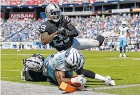  ??  ?? Tennessee Titans running back DeMarco Murray (29) scores a touchdown on a 5-yard run as he is hit at the goal line by Oakland Raiders defenders Bruce Irvin (51) and David Amerson (29) in the second half of their game Sunday in Nashville.