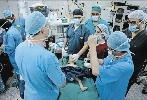  ?? RAAD ADAYLEH THE ASSOCIATED PRESS ?? One-year-old Syrian refugee Eman Zatima is prepared by medical staff for surgery, at a hospital in Amman, Jordan. Eman, who has a heart defect, received a life-saving pro bono surgery from doctors sent by the Vatican's Bambino Gesu Hospital. The infant...