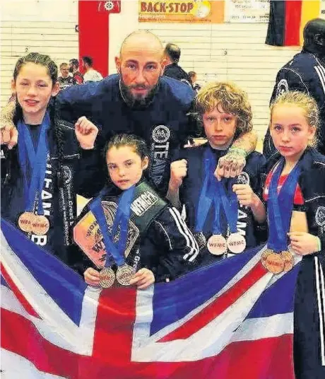  ??  ?? Instructor Kru Rory Robertson is pictured with youngsters Emily Kelly, Liam Derbyshire, Kayla Garvey and Lilly Chandler who all fought superbly to win a clutch of honours in Germany.