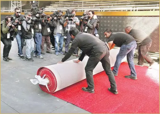  ?? Al Seib Los Angeles Times ?? CREW MEMBERS are hard at work preparing for the 90th Academy Awards. Rudy Morales, from left, Pablo Cruz and Hilberto Flores roll out the red carpet.