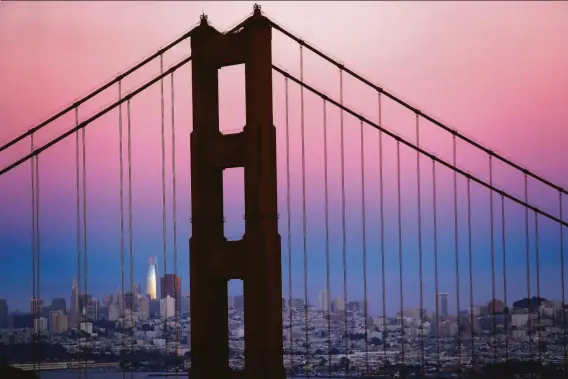  ?? Scott Strazzante / The Chronicle 2019 ?? “You don’t get to hate it unless you love it”: Salesforce Tower and the San Francisco skyline behind the Golden Gate Bridge at dusk.