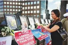  ?? AFP ?? A woman puts flowers yesterday alongside photograph­s of the people killed in the London Bridge terror attack.