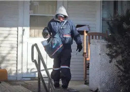  ?? BRYON HOULGRAVE/THE REGISTER FILE ?? Postal carrier Laurie Allen of Winterset bundles up Jan. 20, 2022, in Winterset. The U.S. Postal Service has halted mail delivery to tenants of a Des Moines apartment complex, many of whom are refugees.