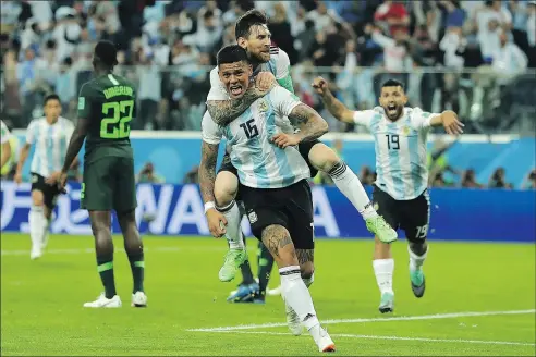  ?? — GETTY IMAGES ?? Argentina’s Marcos Rojo (front) celebrates with teammate Lionel Messi after scoring against Nigeria.