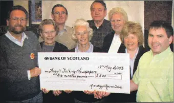  ?? ?? 2003: Derek Meredith, left, of Talking Newspapers and other volunteers receive the £500 cheque from Mid Argyll Round Table treasurer Bruce Johnston.