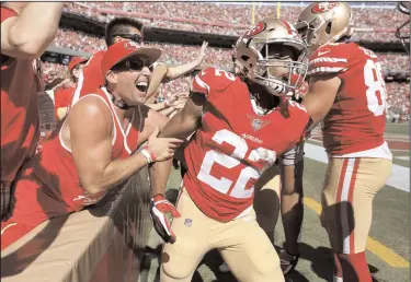  ?? NHAT V. MEYER/TRIBUNE NEWS SERVICE ?? San Francisco 49ers' Matt Breida (22) celebrates his 66-yard touchdown run with 49ers fan Frank Ferrante, from Clayton during their game against the Detroit Lions in the third quarter on Sunday in Santa Clara.