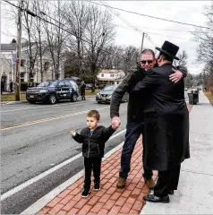  ?? STEPHANIE KEITH / GETTY IMAGES ?? A member of Rabbi Chaim Rottenberg’s community hugs a well-wisher in front of the rabbi’s house Sunday in Monsey, New York.