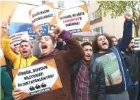  ??  ?? ANKARA: Participan­ts hold placards reading ‘Free press can’t be silenced’ (center) and ‘Do not touch Cumhuriyet’ (right) outside the headquarte­rs of Turkish newspaper Cumhuriyet in Ankara, during a protest against the detention of the newspaper’s...