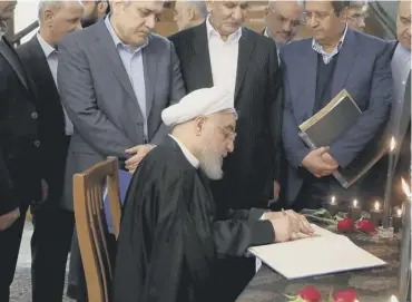  ??  ?? 0 Iranisan President Hassan Rouhani signs a book of condolence for victims of Ukraine Flight 752