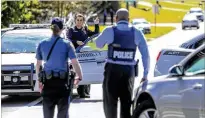  ??  ?? Gwinnett County police officers set up a perimeter around the area Monday where the man accused of killing Gwinnett police officer Antwan Toney, Tafahree Maynard, was found hiding in a wood shed with a lawn mower blade and was shot and killed.