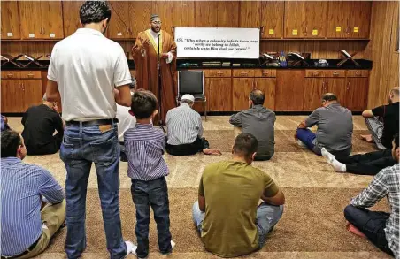  ?? Bob Owen / San Antonio Express-News ?? In a temporary building, Imam Osama Hassan delivers a sermon Friday with a message of forgivenes­s to congregant­s of the Victoria Islamic Center listen, one day after a suspect appeared in federal court in connection with the January fire that destroyed...