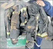  ?? Picture: LULAMILE FENI ?? WHAT PROTECTION? A KSD firefighte­r shows the poor quality of their protective clothing