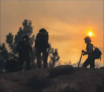  ?? Gina Ferazzi Los Angeles Times ?? A FIRE CREW fights the Cranston fire near Idyllwild on Wednesday. “It came up on us really, really quickly. Within a half-hour, the whole town was overwhelme­d with f lames,” resident Joe Achtner said.