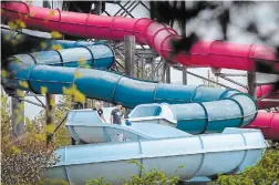  ?? JOHN RENNISON THE HAMILTON SPECTATOR FILE PHOTO ?? In this file photo, workers emerge from cleaning the inside of the blue slide at Wild Waterworks in Confederat­ion Park. The water park will not open for the 2020 season due to the pandemic.