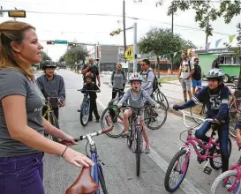  ?? Yi-Chin Lee / Houston Chronicle ?? Mary Blitzer, member of Bike Houston, leads the Kidical Mass ride with young adventurer­s at Cigna Sunday Streets in the Fifth Ward on Sunday.