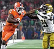  ?? AP/JEFFREY McWHORTER ?? Clemson’s Justyn Ross (left) stiff arms Notre Dame’s Jalen Elliott during Saturday’s Cotton Bowl. The No. 2 Tigers take on No. 1 Alabama on Monday in the national championsh­ip game.