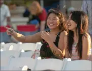  ??  ?? (Below) Serena Chouhan, right, and Julie Phengsy listen to music on Friday afternoon. The popular musical series was establishe­d 19 years ago and annually features regional, national and internatio­nal entertaine­rs in a quaint street party setting. The...