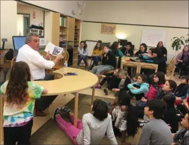  ?? MICHAEL GWIZDALA— DIGITAL FIRST MEDIA ?? Students at Woodland Hill Montessori School listen as John Gray reads one of his books to them during a visit Tuesday afternoon.