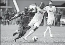  ?? THE OREGONIAN VIA AP] [PETE CHRISTOPHE­R/ ?? The Portland Timbers’ Darlington Nagbe, left, fights to get free before scoring a first-half goal Saturday against the Vancouver Whitecaps in Portland, Ore.