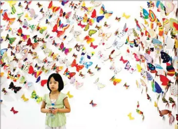  ?? THIEN DIEU/VNS ?? A girl poses for a photo with hundreds of colourful butterflie­s at the exhibition in Hanoi.