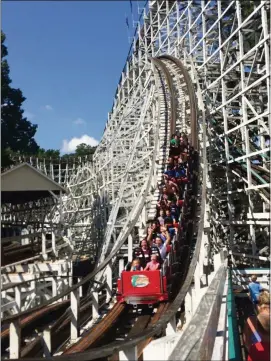  ?? TOM KELLEY PHOTOS / TKELLEY@AJC. COM ?? People enjoy a ride on the Georgia Cyclone at Six Flags Over Georgia. The coaster traverses a series of hills, twists and turns, with barely any straight sections of track.