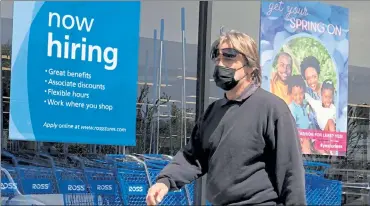  ?? JUSTIN SULLIVAN / GETTY IMAGES ?? A pedestrian walks by a ‘now hiring‘ sign at Ross Dress For Less store on Friday in San Rafael, Calif.