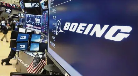  ??  ?? Fuelling sales: A file picture shows Boeing’s stock above a trading post on the floor of the New York Stock Exchange. While the company has studied retrofitti­ng the used 777 wide-bodies for more than a decade, the effort has taken on new life in recent...