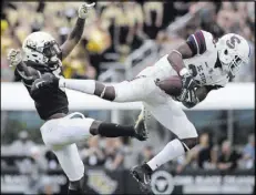  ?? Phelan M. Ebenhack The Associated Press ?? South Carolina State cornerback Chris Adams intercepts a pass intended for Central Florida wide receiver Dedrick Snelson in the first half of the Knights’ 38-0 win Saturday.