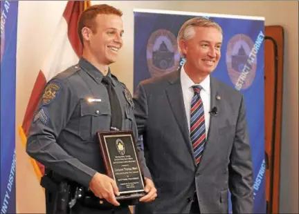  ?? GENE WALSH — DIGITAL FIRST MEDIA ?? Montgomery County District Attorney Kevin Steele presented Montgomery Township Cpl. Thomas Ward with a commendati­on during an event in Plymouth on May 11.