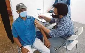  ?? EIZAIRI SHAMSUDIN PIC BY ?? A senior citizen receiving a vaccine at the World Trade Centre Kuala Lumpur yesterday. Starting yesterday, senior citizens in the Klang Valley may walk into inoculatio­n centres to receive vaccines.