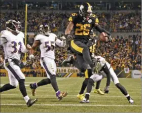  ?? DON WRIGHT — THE ASSOCIATED PRESS FILE ?? In this file photo, Pittsburgh Steelers running back Le’Veon Bell (26) leaps into the end zone ahead of Baltimore Ravens strong safety Eric Weddle (32) for a touchdown during the second half of an NFL football game in Pittsburgh. The Steelers have put...