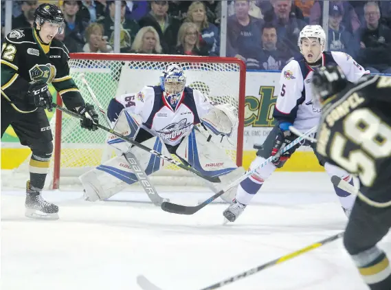  ?? MIKE HENSEN/POSTMEDIA NEWS ?? Janne Kuokkanen of the London Knights attempts to deflect a shot from teammate Mitchell Vande Sompel past Windsor goalie Michael DiPietro with Austin McEneny of the Spitfires in front of the net during their Friday game at Budweiser Gardens. London...