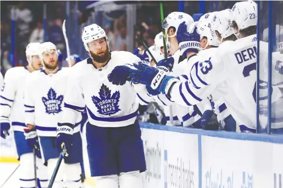  ?? KIM KLEMENT/USA TODAY SPORTS ?? Jake Muzzin is congratula­ted by teammates after scoring a goal in Toronto’s 4-3 win over Tampa Bay on Tuesday night. He later suffered a broken hand.