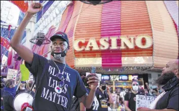  ??  ?? Stretch Sanders raises a fist Saturday at the Fremont Street Experience during Justice for Breonna Taylor and the Las Vegas Victims of Police Terrorism March.
