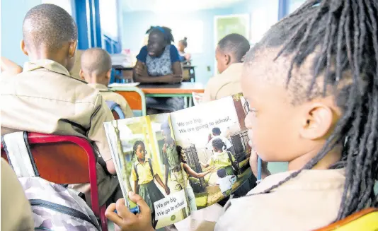  ?? FILE PHOTOS ?? Students read during a ‘Drop everything and Read’ session at Grove Primary School in East Rural St Andrew. Don Robotham writes: There should be an increase in library teachers and the library service, whose sole task will be to support the work of the reading specialist­s.