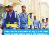  ??  ?? DOHA: This file photo taken on May 4, 2015 shows foreign laborers walking back to their accommodat­ion in the Al-Wakrah suburb. —AFP