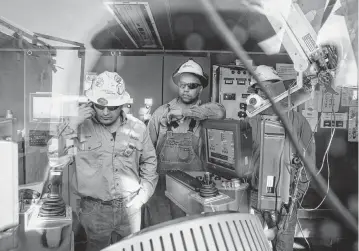  ?? ILANA PANICH-LINSMAN NYT ?? Driller Cristo Flores, left, and Michael Manga, a rig manager, address a drill issue in 2017 on a rig in Midland, Texas.