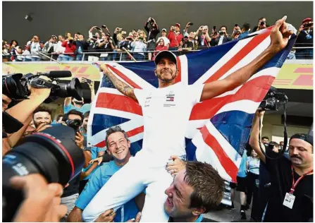  ?? — AFP ?? One of a kind: Lewis Hamilton celebratin­g with his team after winning his fifth Formula One world championsh­ip title at the Mexican Grand Prix on Sunday.