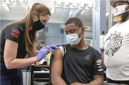  ?? ANTHONY VAZQUEZ/SUN-TIMES FILES ?? Terrell Hallom, 15, receives a COVID-19 vaccine dose last year at a site in the Englewood neighborho­od. A new study suggests 255 lives could have been saved in Chicago if vaccine coverage had been more uniform across the city.