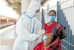  ?? —REUTERS ?? BRACING FOR A CRISIS A health-care worker in personal protective equipment collects a swab sample from a woman amid the spread of the coronaviru­s disease at a railway station in Mumbai, India, on April 16.