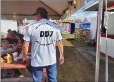  ??  ?? Ed Munhall shows off his family’s demolition derby t-shirt.