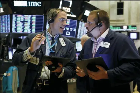  ?? RICHARD DREW — THE ASSOCIATED PRESS FILE ?? Traders Gregory Rowe, left, and Michael Milano work on the floor of the New York Stock Exchange.