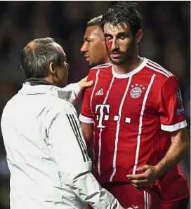  ??  ?? Help me: A bleeding Javi Martinez receiving medical treatment after scoring Bayern Munich’s second goal against Celtic. — AP