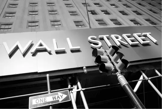  ?? AP ?? A sign onr a Wall Street building is shown in New York on June 16.