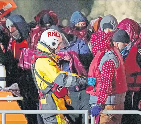  ?? ?? CROSSINGS: People take part in a protest outside the Home Office, top, and migrants brought in to Dover.