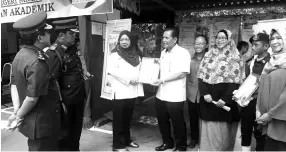  ??  ?? Maimunah (third left) presenting a prize to Keningau Vocational College director Johari Sabin during the exhibition yesterday.